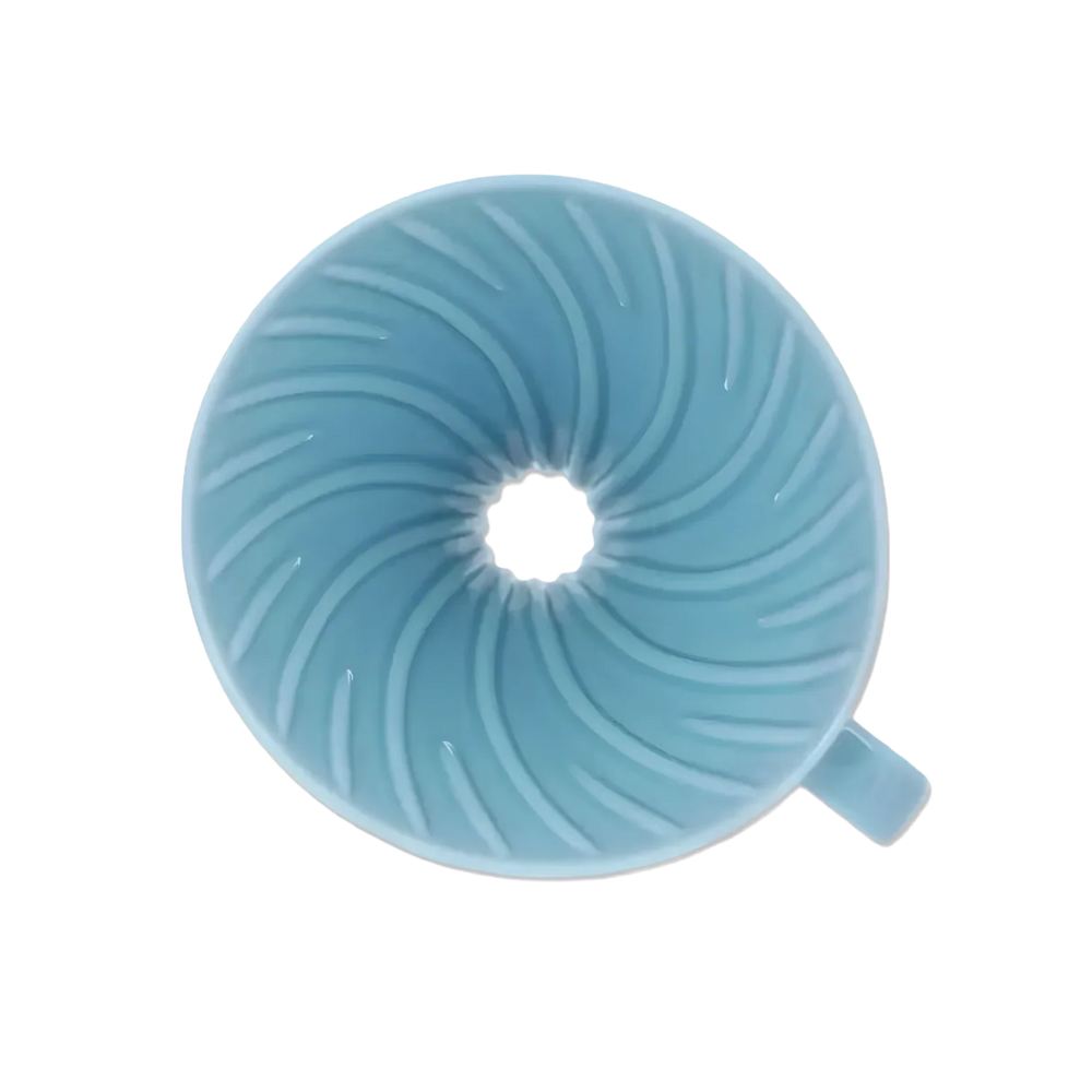 Top view inside the light blue Hario V60 ceramic dripper showing spiral ribs and large drip hole
